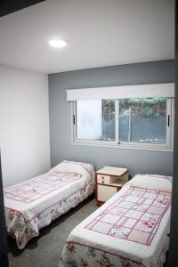 a bedroom with two beds and a window at un sueño para viajar in Ciudad Lujan de Cuyo