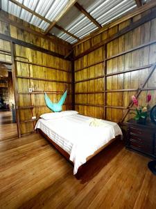 a bedroom with a bed in a wooden wall at Cabañas Arrecifes in El Valle