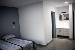 um quarto com uma cama e um espelho na parede em un sueño para viajar em Luján de Cuyo