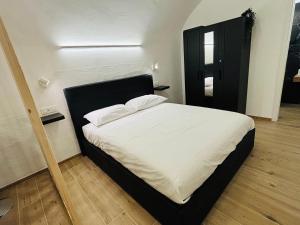 a bedroom with a large bed with a black headboard at La Petite Suite in Sanremo +4 photos