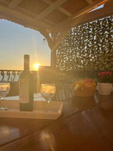 butelkę wina i dwa kieliszki na stole w obiekcie Apartments by the sea Suhi Potok, Omis - 11401 w mieście Jesenice