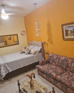 uma sala de estar com uma cama e um sofá em Casa Maria Flor em Arraial do Cabo