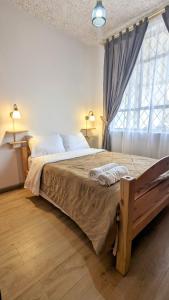 um quarto com uma cama grande e uma janela em Beautiful room near everything 2 em Cuenca