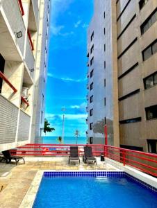 a swimming pool in the middle of two buildings at Flat vista mar Boa Viagem in Recife