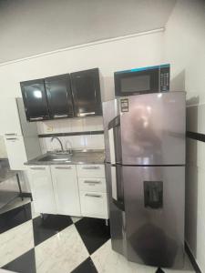Una cocina con refrigerador y gabinetes de acero inoxidable. en La torrecita, en Barbosa