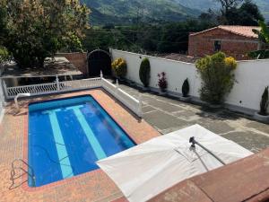 uma piscina com uma cobertura branca ao lado de uma casa em La torrecita em Barbosa