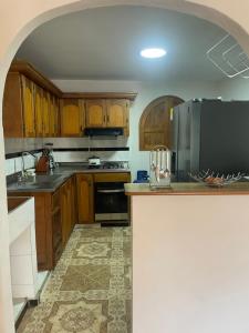 uma cozinha com armários de madeira e electrodomésticos de aço inoxidável em La torrecita em Barbosa
