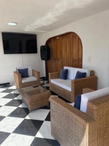 uma sala de estar com cadeiras de vime e um sofá em La torrecita em Barbosa