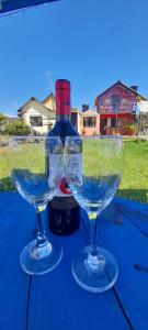 托塔的住宿－Hospedaje Maria Valentina，两杯酒杯坐在桌子上,并配上一瓶葡萄酒