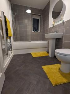 a bathroom with a sink and a toilet and a tub at Freshen-up stays Doncaster in Bentley