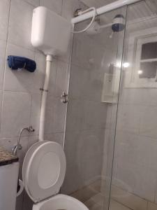 a bathroom with a toilet and a glass shower at Hostel Sandra in Búzios