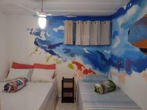 a bedroom with two beds and a blue and white wall at Hostel Sandra in Búzios