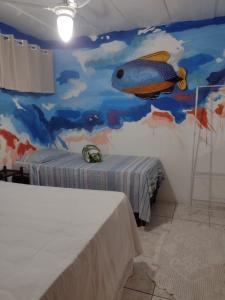 1 dormitorio con un mural de pescado en la pared en Hostel Sandra, en Búzios