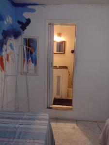 a white room with a mirror and a bathroom at Hostel Sandra in Búzios