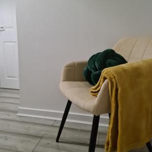 a green blanket sitting on a chair in a room at Freshen-up stays Doncaster in Bentley