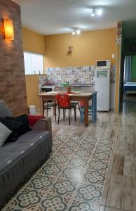 uma sala de estar com um sofá, uma mesa e uma cozinha em Aconchegante Casa em São Lourenço