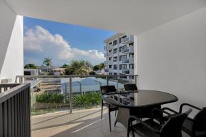 a balcony with a table and chairs and a building at Dual Key Three Bedroom Apartment close to CBD in Mackay