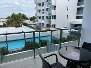 a balcony with a table and chairs and a swimming pool at Dual Key Three Bedroom Apartment close to CBD in Mackay