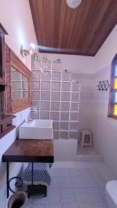 La salle de bains blanche est pourvue d'un lavabo et d'une fenêtre. dans l'établissement Casa da felicidade praia do forte 2 quartos, à Itaparica Town