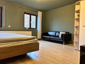 ein Schlafzimmer mit einem Bett und einem Ledersofa in der Unterkunft Kraewelhof in Schrozberg