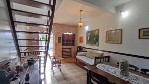 a living room with a spiral staircase in a house at Casa da felicidade praia do forte 2 quartos in Itaparica