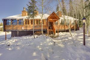 una cabaña de madera en la nieve con un patio cubierto de nieve en Charming Brian Head Condo Rental with Ski Shuttle!, en Brian Head