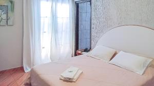 a white bed with a laptop on top of it at Victoria Hotel - Campanha - MG in Campanha