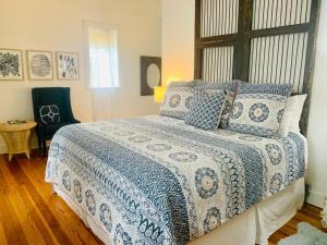 a bedroom with a bed with a blue and white comforter at Gardens of Baron's Creek - Unit D in Fredericksburg