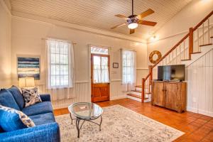 a living room with a blue couch and a tv at Gardens of Baron's Creek - Unit D in Fredericksburg