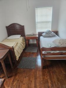 a room with two beds and a table and a window at RestStop Hostel in Houston