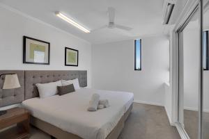a white bedroom with a large bed with white sheets at Stunning 2 Bedroom Self Contained City Apartment in Mackay +5 photos