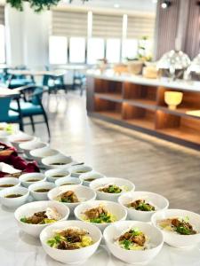 una fila de tazones de comida sobre una mesa en ViAn Hotel And Spa Danang, en Da Nang