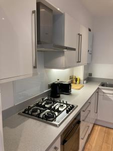 a kitchen with a stove top oven in a kitchen at Two double bedroom flat in Soho in London