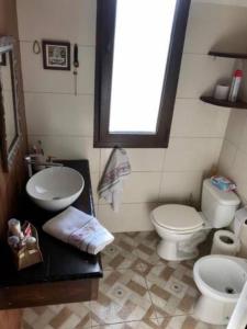 een badkamer met 2 toiletten, een wastafel en een raam bij The Wall Montevideo [104] Live in the Old Town in Montevideo
