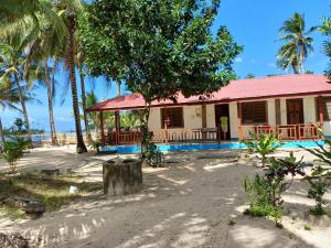 una casa en la playa con palmeras en Calitang Pearl Cottage en Nacpan