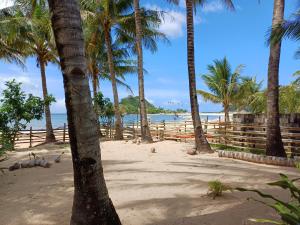 a group of palm trees on a sandy beach at Calitang Pearl Cottage in Nacpan