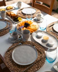 une table avec des assiettes de nourriture et des verres dans l'établissement Vila Caetanos, à Amontada