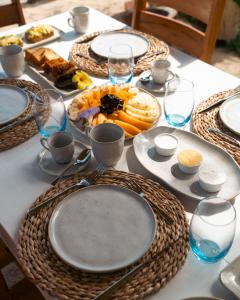 a table with plates of food and glasses on it at Vila Caetanos in Amontada +51 photos