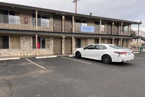 a white car parked in a parking lot in front of a building at Anchor Bay Inn By OYO Reedsport in Reedsport