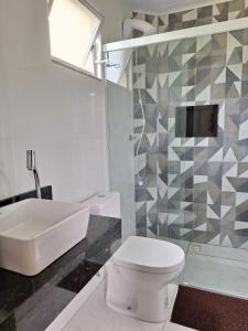 a bathroom with a white toilet and a sink at Residencial Caramujo in Florianópolis