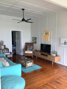 a living room with a blue couch and a tv at Good Vibes, 18 East Street in Crescent Head