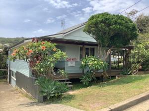 a house with trees and plants in front of it at Good Vibes, 18 East Street in Crescent Head