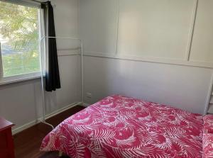 a bedroom with a pink bed with a window at Good Vibes, 18 East Street in Crescent Head