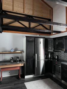 een keuken met een roestvrijstalen koelkast en houten kasten bij Villa Aronia in Porvoo