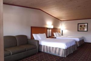 a hotel room with two beds and a couch at Anchor Bay Inn By OYO Reedsport in Reedsport