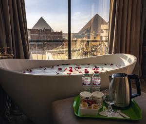 a bath tub in a room with a view of pyramids at Sphinx golden gate pyramids view in Cairo