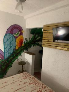 a bedroom with a painting of a bird on the wall at Suite confortável 5 in Florianópolis