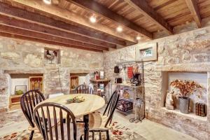 Un comedor con mesa y sillas de madera. en The Rock House Hideaway - TANK HOUSE, en Fredericksburg