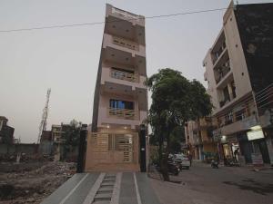 um edifício alto com uma porta no meio de uma rua em OYO Flagship 9075 Petals Inn em Noida