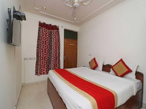 a bedroom with a large bed with a red blanket at OYO Flagship Hotel S Suites in New Delhi